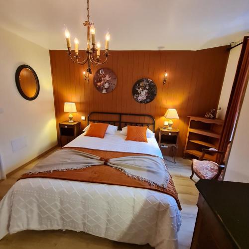 une chambre avec un grand lit et un lustre dans l'établissement Appartement Puy Mary By les Monts du Cantal, à Murat