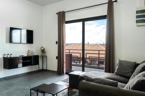 a living room with a couch and a large window at Yasmin Luxury Resort in Paramaribo