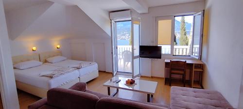 a room with a bed and a couch and a tv at Villa Boka Sunrise Apartments in Herceg-Novi