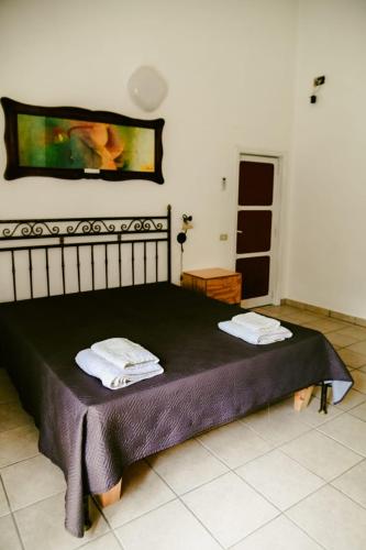 a bedroom with a bed with two towels on it at Appartamenti Frassanito in Conca Specchiulla