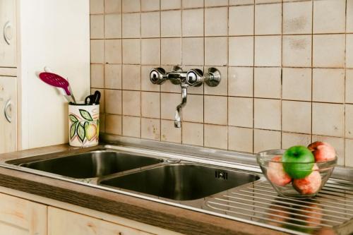 a sink in a kitchen with a bowl of fruit at Appartamenti Frassanito in Conca Specchiulla