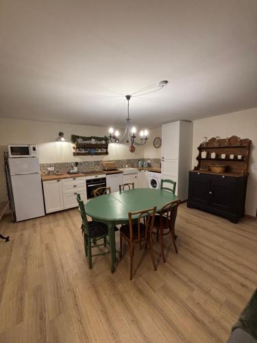 a kitchen with a green table and chairs in a room at Appartement Puy Mary By les Monts du Cantal in Murat