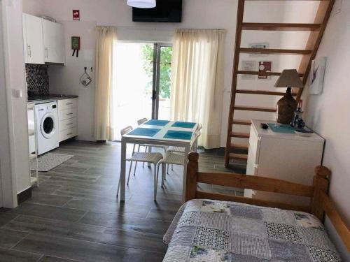 a kitchen with a table and a kitchen with a staircase at Casa da Avó Olinda in Góis