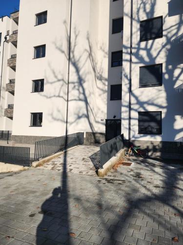a shadow of a tree in front of a building at Apartmani Nikmil Vrnjačka Banja in Vrnjci