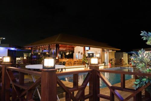 a restaurant with a table and a pool at night at Yasmin Luxury Resort in Paramaribo