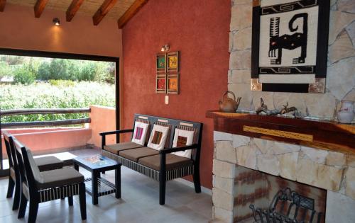 a living room with a fireplace and a couch and chairs at Colores de Purmamarca in Purmamarca