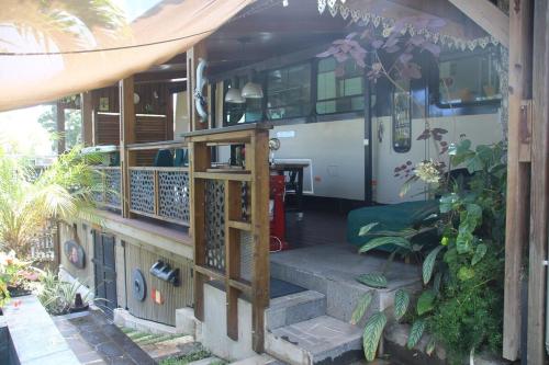 a front porch of a house with a bus at le mangue car hôte in Saint-Paul