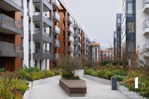 un banco frente a un edificio con jardín en Penthouse Brabank Luxury Japandi Sauna&Fitness free parking by Grandview, en Gdansk