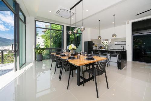 eine Küche und ein Esszimmer mit einem Holztisch und Stühlen in der Unterkunft Patong Cliff Villa Phuket 12 bedroom in Patong Beach