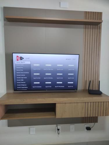 a flat screen tv sitting on a wooden shelf at Casa Amar Cabo Frio in Cabo Frio
