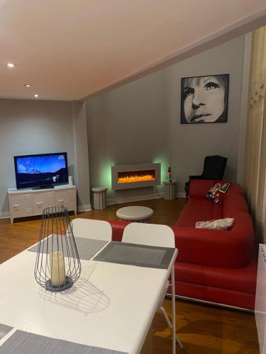 a living room with a red couch and a fireplace at 1 Morpeth Court in Morpeth