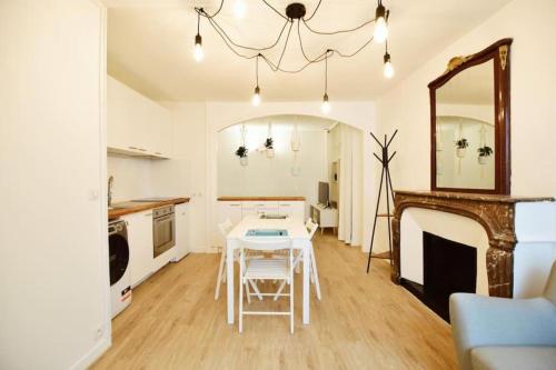 - un salon avec une table et un miroir dans l'établissement 07 grand studio on the Place des Vosges, à Paris