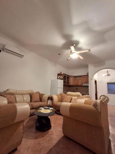 a living room with two couches and a ceiling fan at Hills Villa in Vlorë