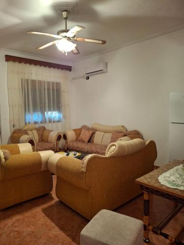 a living room with two couches and a ceiling fan at Hills Villa in Vlorë