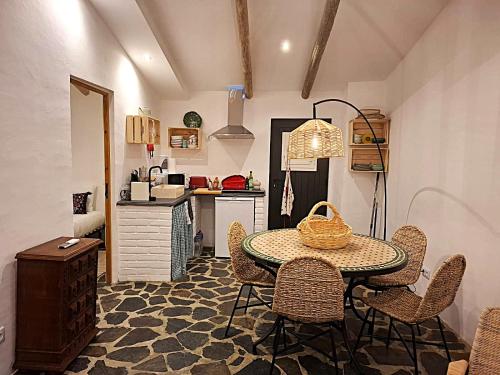 a kitchen with a table and chairs in a room at Descanso dos oleiros in Aldeia do Mato