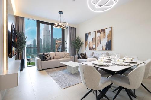 a white living room with a table and chairs at High-Floor Luxe 2BR Stunning Burj Khalifa & Fountain Views Direct Dubai Mall Access in Dubai