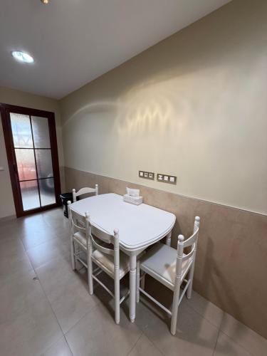 a dining room with a white table and chairs at Piso de lujo Golf y Playa in Estepona