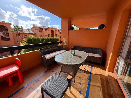 a patio with a table and chairs on a balcony at Piso de lujo Golf y Playa in Estepona