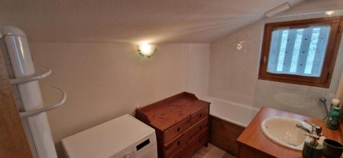 La salle de bains est pourvue d'un lavabo et d'une fenêtre. dans l'établissement Appartement familial pour ski et rando, à La Giettaz