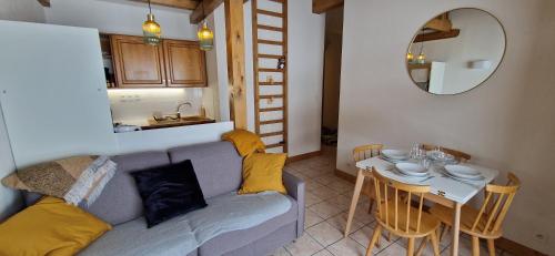 - un salon avec un canapé et une petite table dans l'établissement Appartement familial pour ski et rando, à La Giettaz