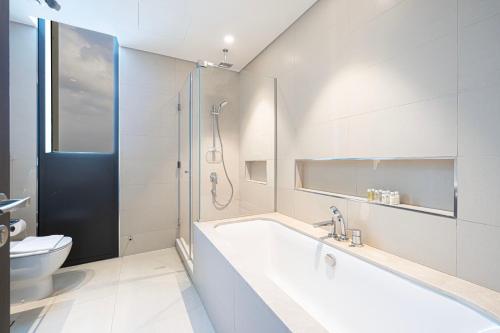 a bathroom with a tub and a toilet and a shower at High-Floor Luxe 2BR Stunning Burj Khalifa & Fountain Views Direct Dubai Mall Access in Dubai