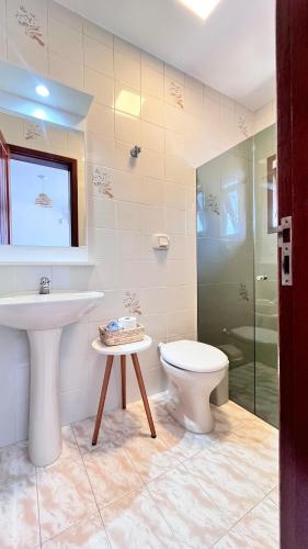 a bathroom with a sink and a toilet and a shower at Casa da Praia Pousada in Torres