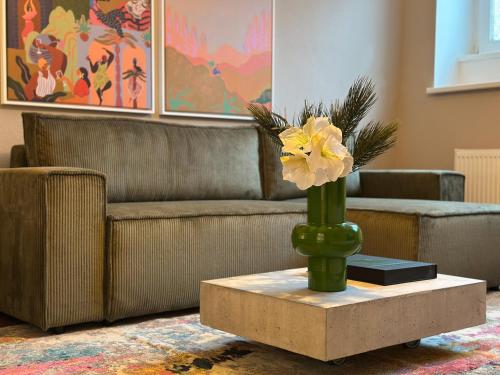 a vase with a flower on a table in a living room at Design Apartment - Self-Check-In - Maschsee in Hannover