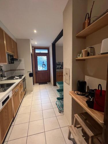 a kitchen with a large white tiled floor at Chalet Mignon - your vacation oasis at Lake Brienz in Bönigen