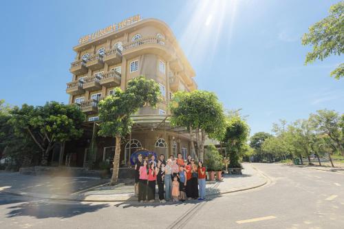 a group of people standing in front of a building at Premium CGP Hotel Hoi An in Hoi An