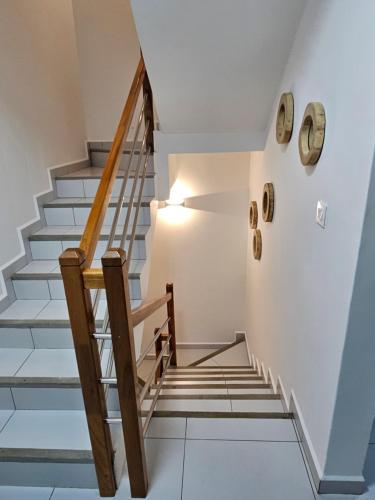 a staircase in a house with white walls and wooden railings at Villa Azure Flic-en-Flac 5 min de la plage in Flic-en-Flac