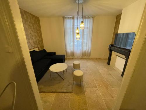 - un salon avec un canapé noir et un piano dans l'établissement Le Havre de Charme, à Boulogne-sur-Mer