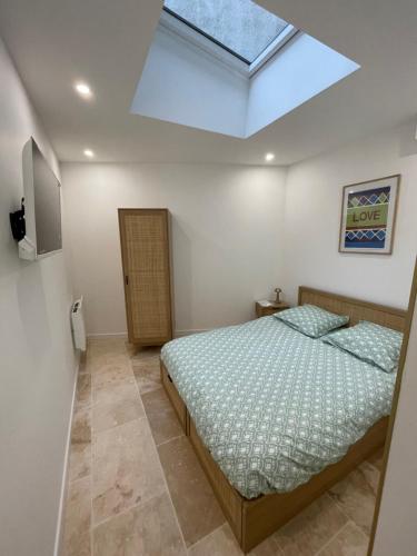 une chambre avec un lit et une lucarne dans l'établissement Le Havre de Charme, à Boulogne-sur-Mer