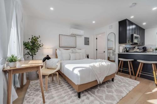 a bedroom with a bed and a table and a kitchen at Brand New Apt W Parking Blocks From Downtown- A in Sunnyvale