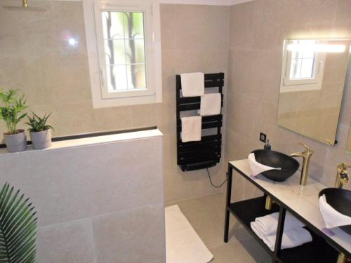 une salle de bain avec un lavabo, une baignoire et un miroir dans l'établissement Villa la Câline, à Maillane