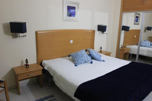 une chambre avec un lit avec des oreillers bleus dessus dans l'établissement Apartamento T1 Quinta Nova - Alvor, à Alvor