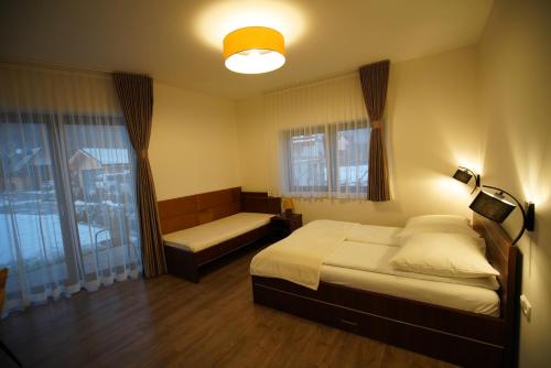 a bedroom with a bed and a couch and a window at Willa Asia in Sromowce Niżne