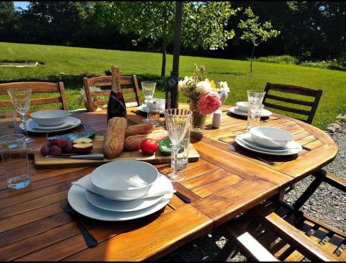 une table en bois avec des assiettes de nourriture dessus dans l'établissement Gite de la foret, à Saint-Plantaire
