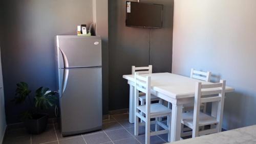 eine Küche mit einem weißen Tisch und einem Kühlschrank in der Unterkunft Dpto en San Antonio Oeste 2 pax in San Antonio Oeste