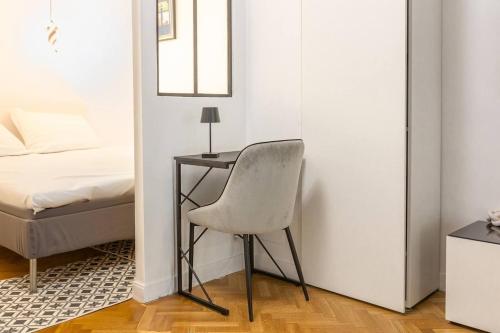- une chambre avec un bureau et une chaise à côté d'un lit dans l'établissement Stylish Escape in the Vibrant 11th arrondissement, à Paris