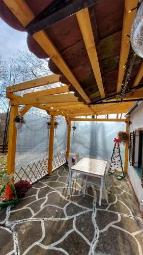a wooden pergola with a table on a patio at Vikendica WoodNook Kosmaj - Šumski kutak in Sopot