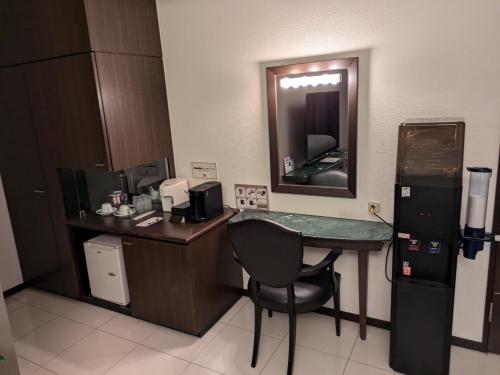 a hotel room with a desk and a chair in a room at ホテル リズコート HOTEL Liz court in Sendai
