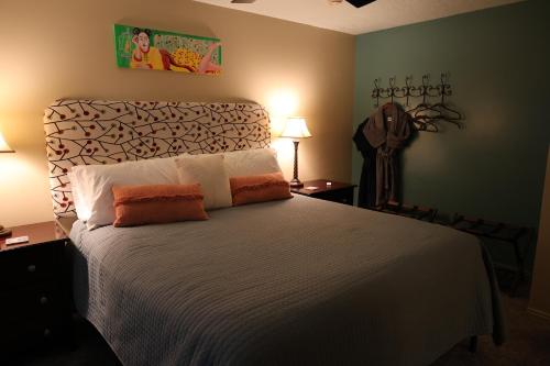 a bedroom with a large bed with white sheets and orange pillows at Harvest House Bed and Breakfast in Springdale