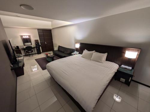a bedroom with a large bed and a living room at ホテル リズコート HOTEL Liz court in Sendai