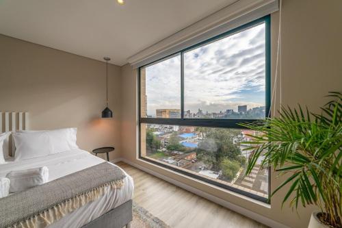 a bedroom with a large window with a city view at Loft en Bogota Centro Internacional in Bogotá