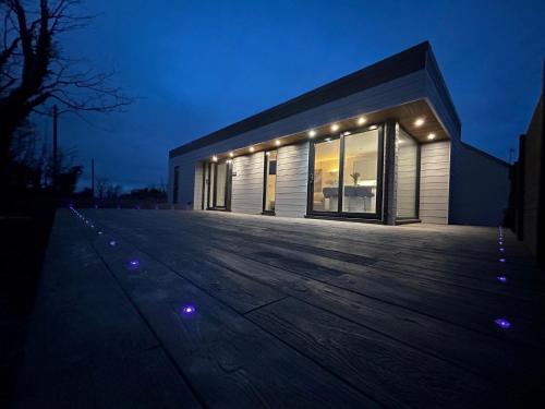a building with lights in front of it at night at Lowern, Luxury Lodge with Hot Tub and Games Room in Menai Bridge