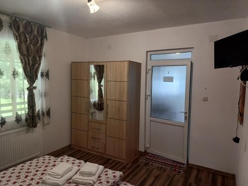 a bedroom with two beds and a closet and a door at Casa de Piatră - Colț de Rai in Arieşeni