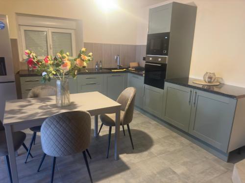 a kitchen with a table with a vase of flowers on it at Maison istoriquie in Vescheim