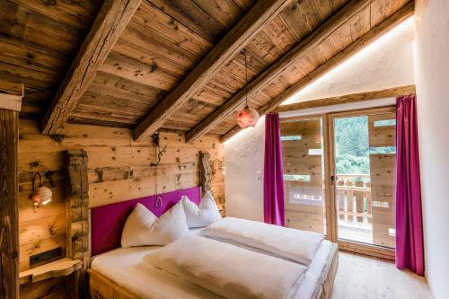 a bedroom with two beds in a room with wooden walls at Chalet Wildberg in Grossarl