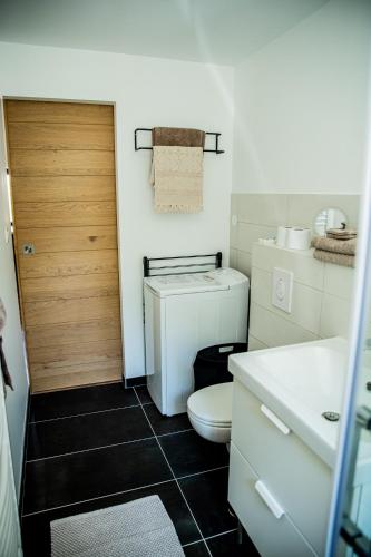 une salle de bain avec toilettes et porte en bois dans l'établissement Château les Poules, à Assignan