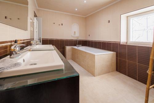 La salle de bains est pourvue de 2 lavabos, d'une baignoire et d'une fenêtre. dans l'établissement Les diamants blancs, à Cruzilles-lès-Mépillat
